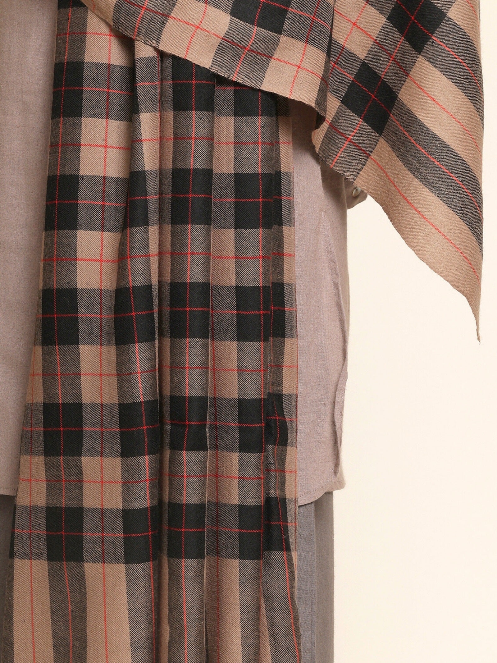 Man wearing a beige and black checkered Shawl