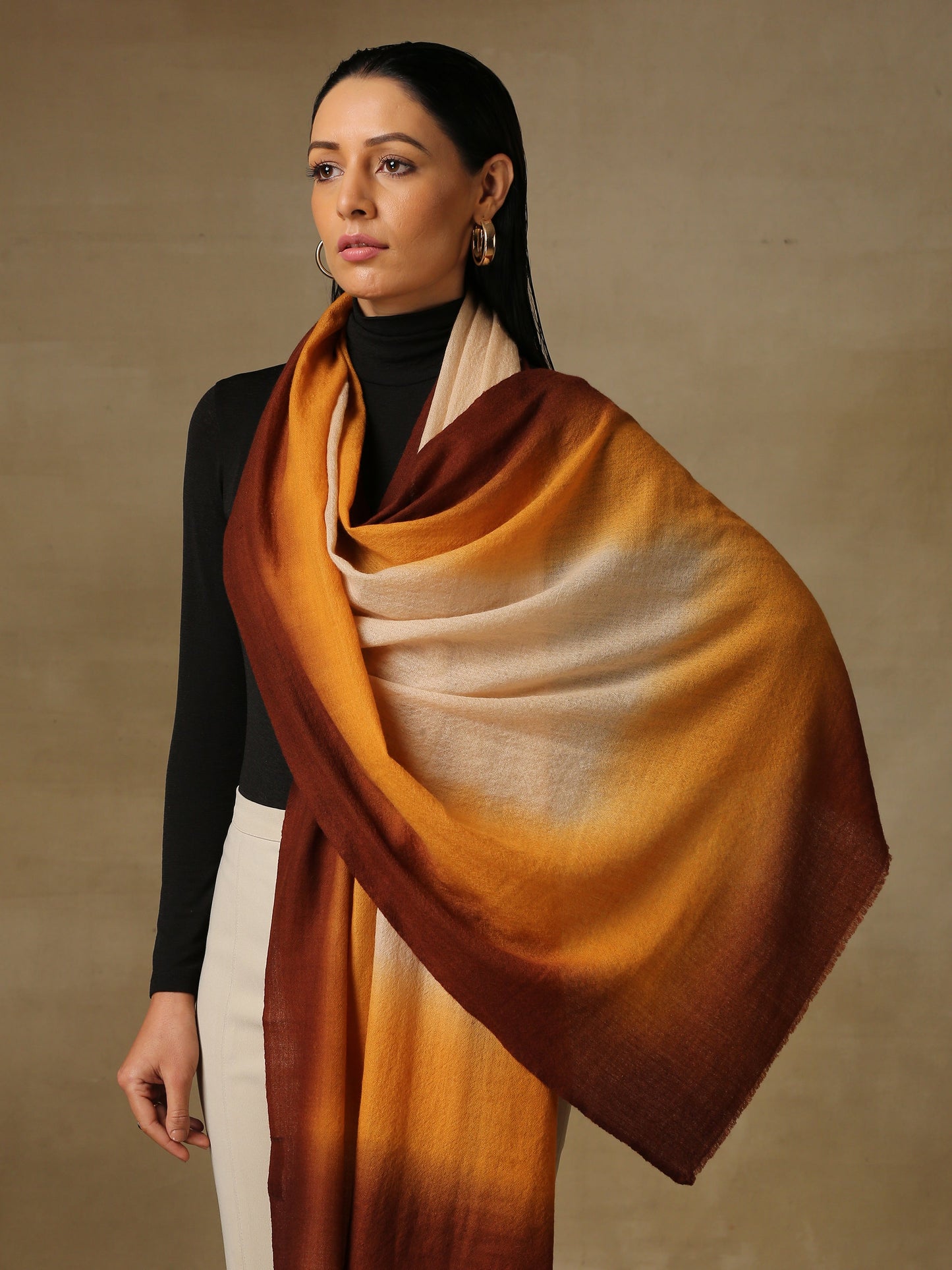 Model is wearing a Saya Ombre stole from Shaza, in the colour Sand : Beige, orange and brown.