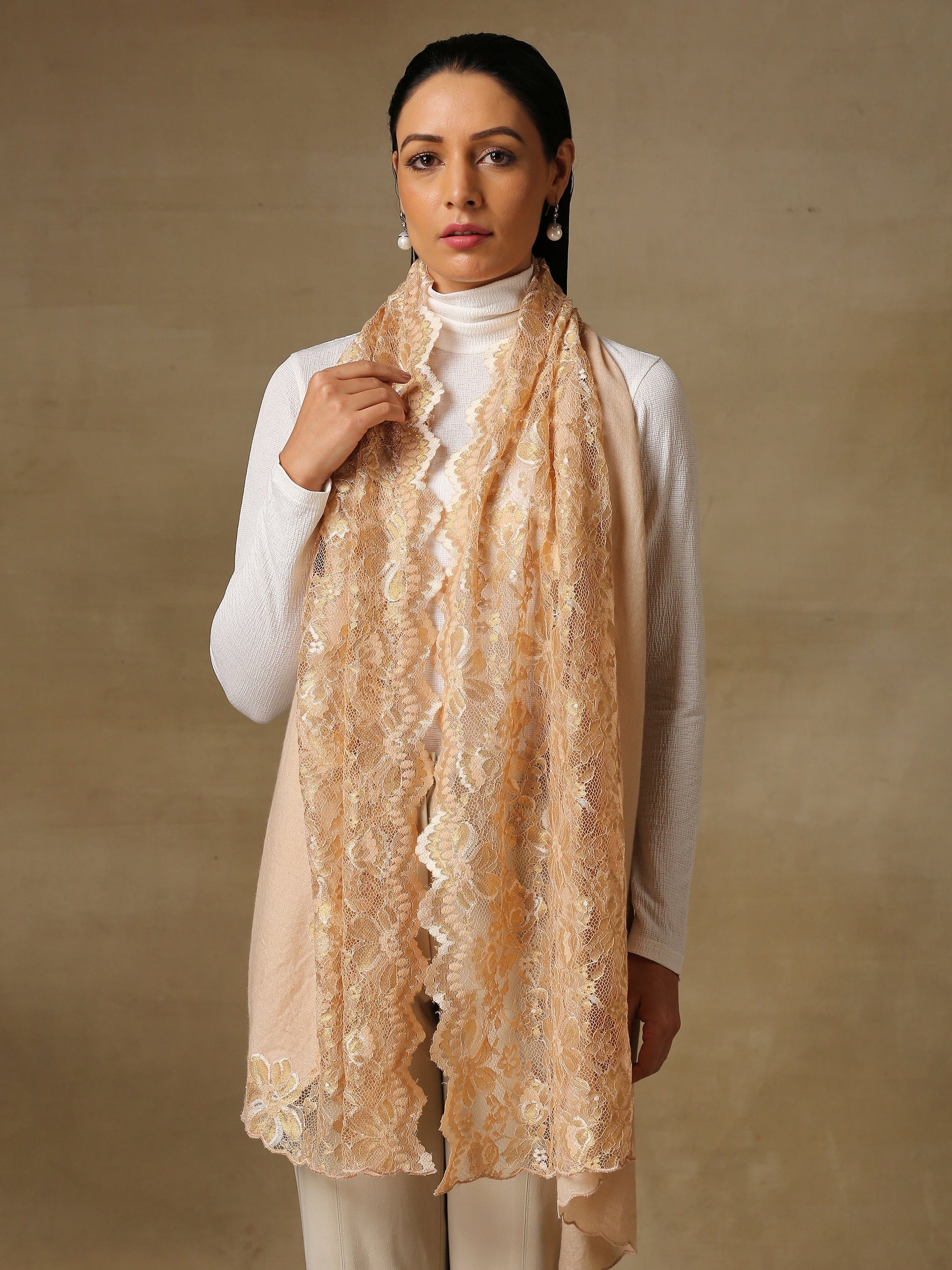 Model is wearing a Pashmina celestial chantilly stole in the colour gold. 