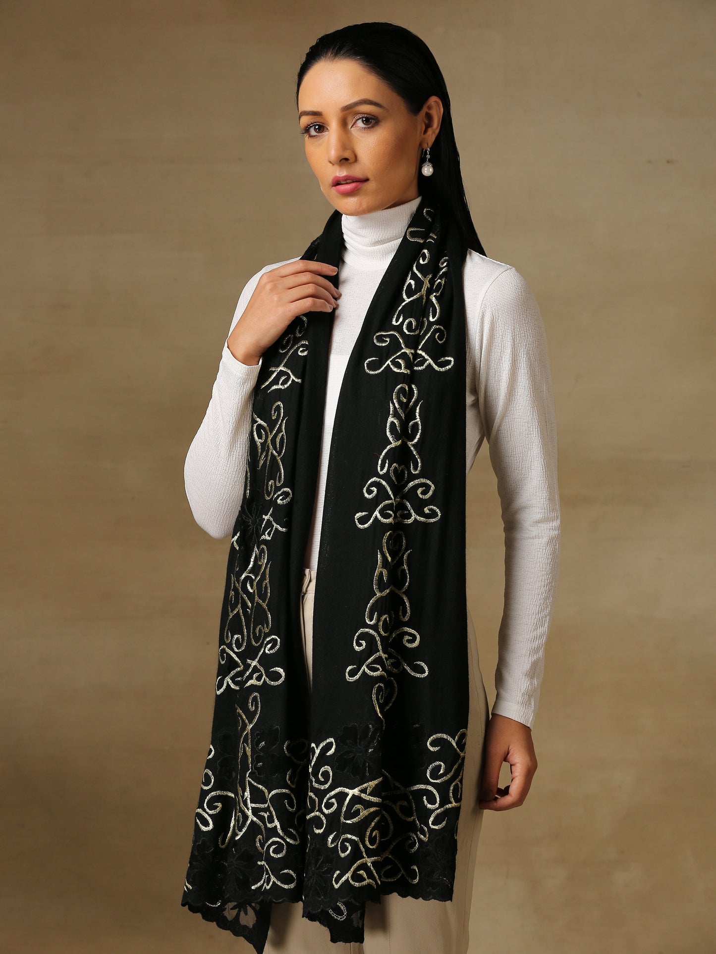 Model is wearing a Vineyard stole in the colour black, featuring curvy shaped cutwork and zari detailing. 