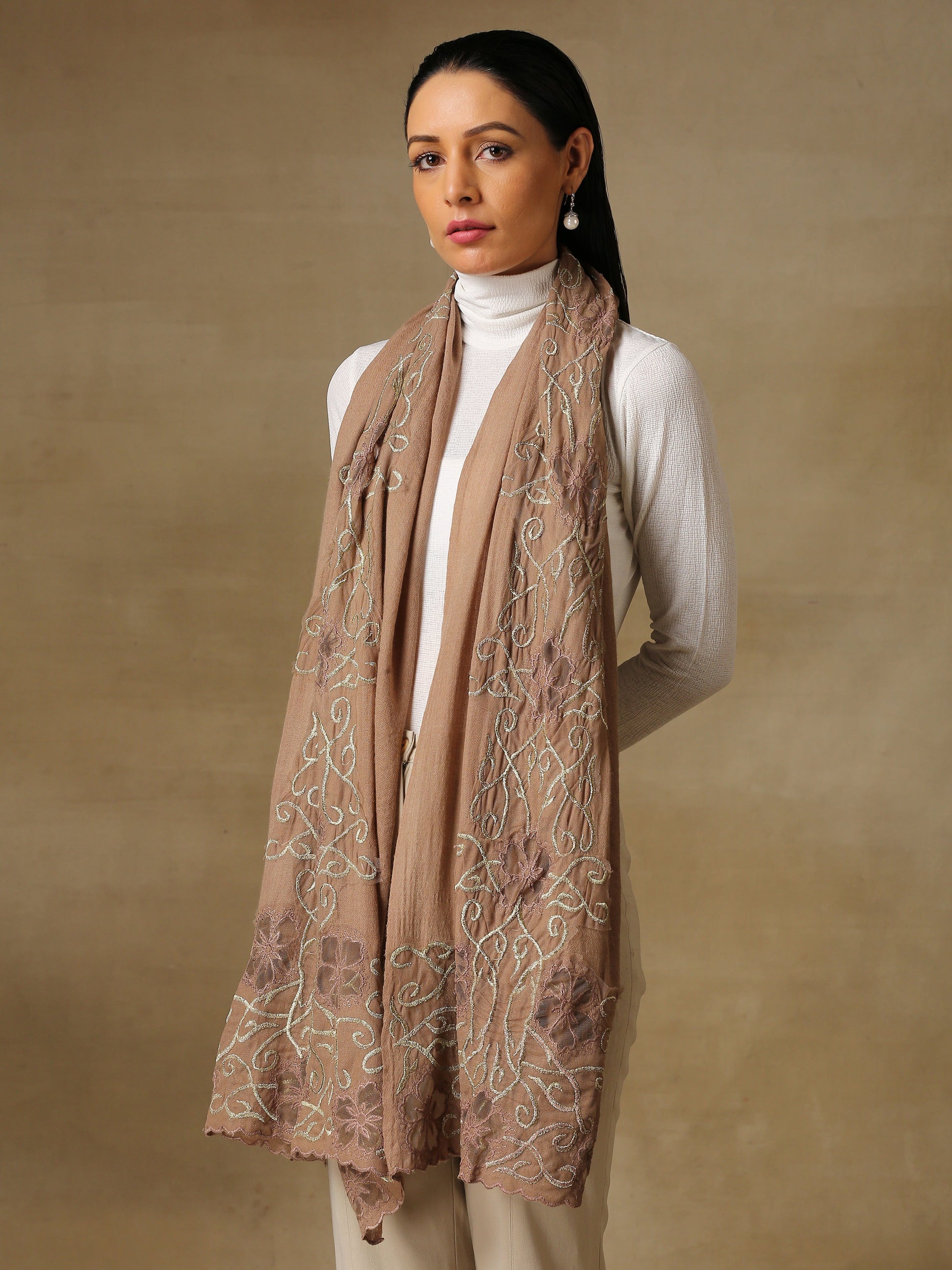 Model is wearing a Vineyard stole in the colour brown, featuring vine shaped cutwork and zari detailing. 