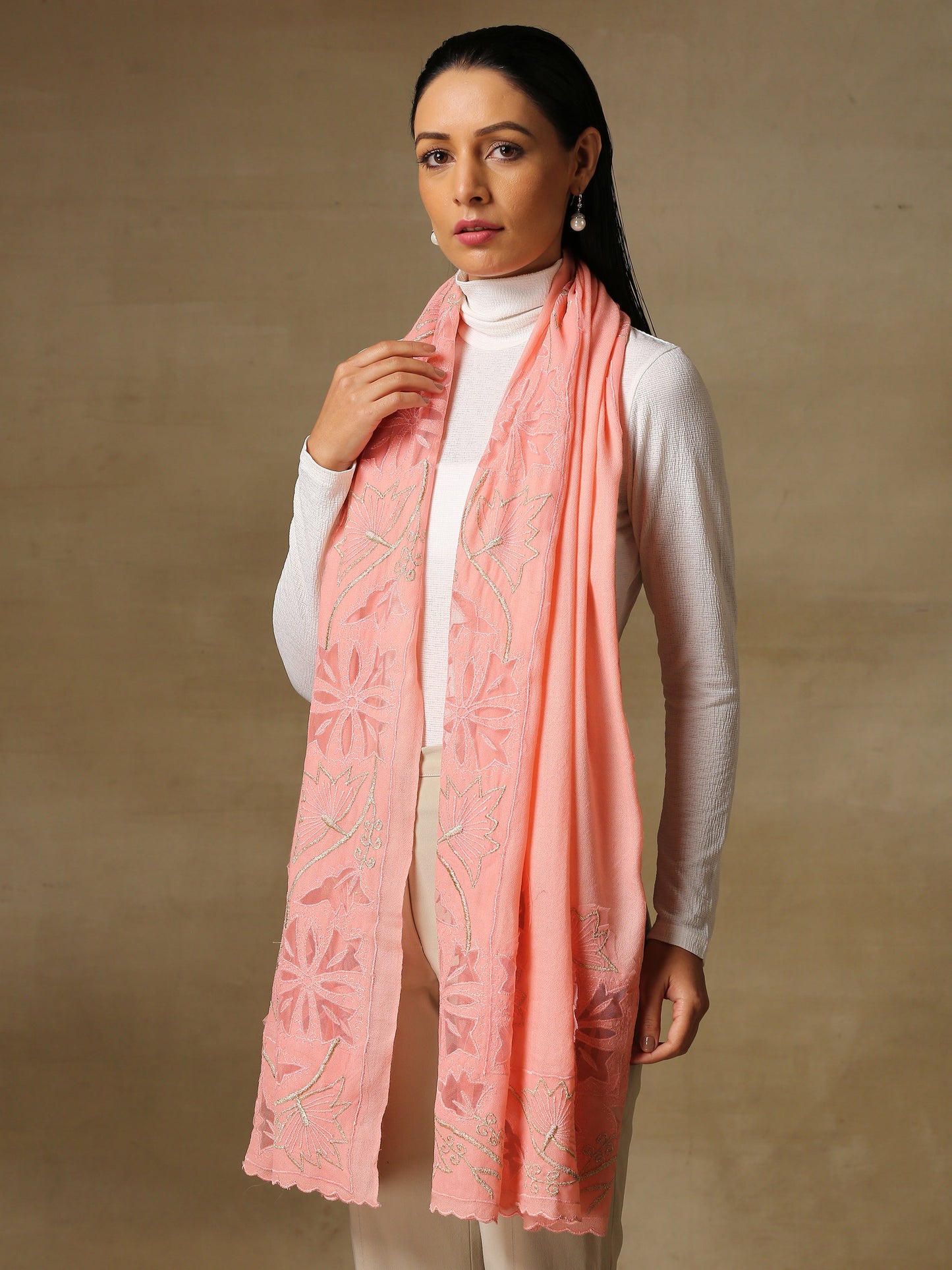 Model is wearing a Vineyard stole in the colour peachy pink, featuring vine shaped cutwork and zari detailing. 