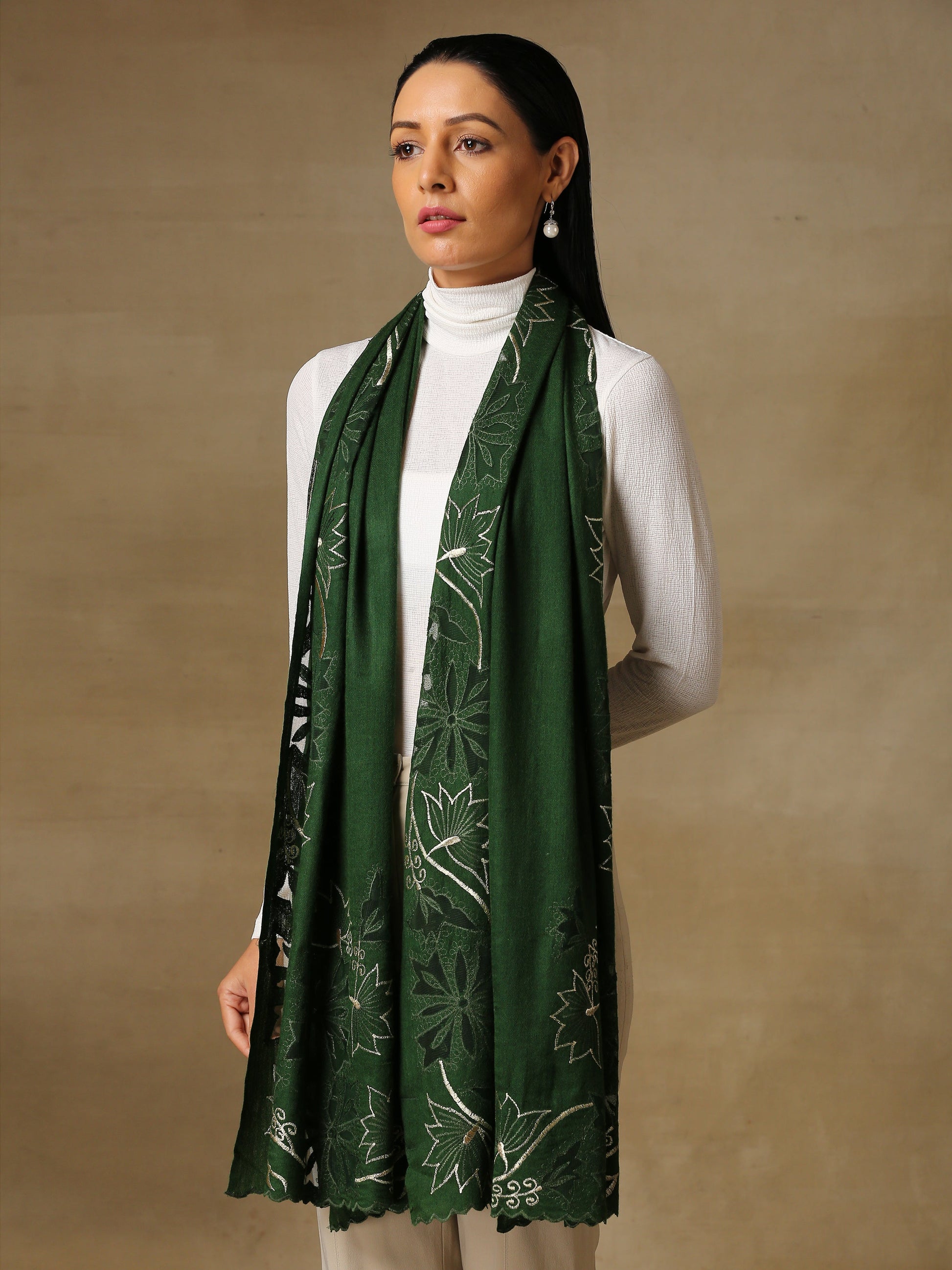 Model is wearing a Vineyard stole in the colour forest green, featuring vine shaped cutwork and zari detailing. 
