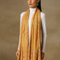 Model is wearing a Vineyard stole in the colour mustard, featuring vine shaped cutwork and zari detailing. 