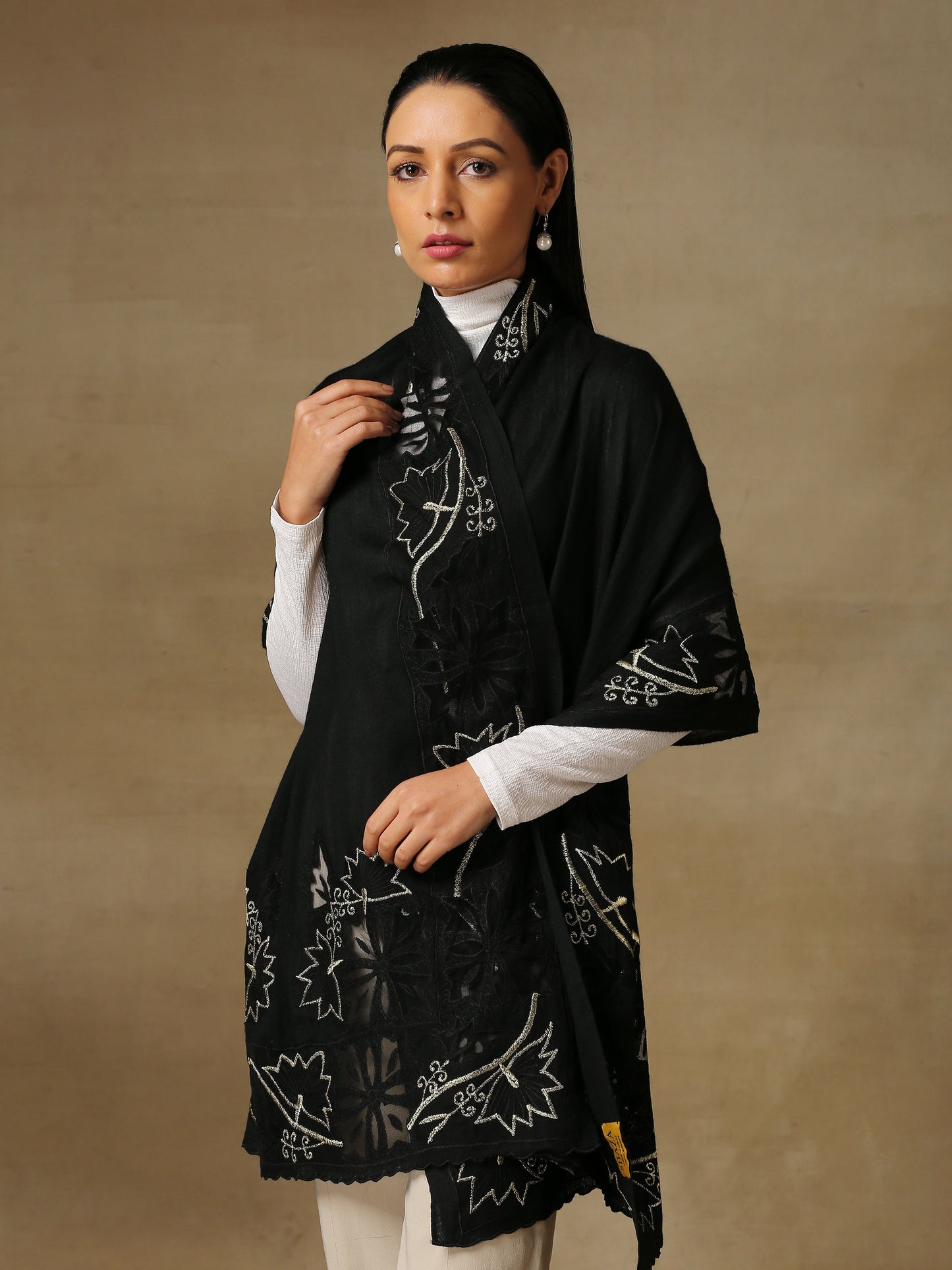 Model is wearing a Vineyard stole in the colour black, featuring vine shaped cutwork and zari detailing. 