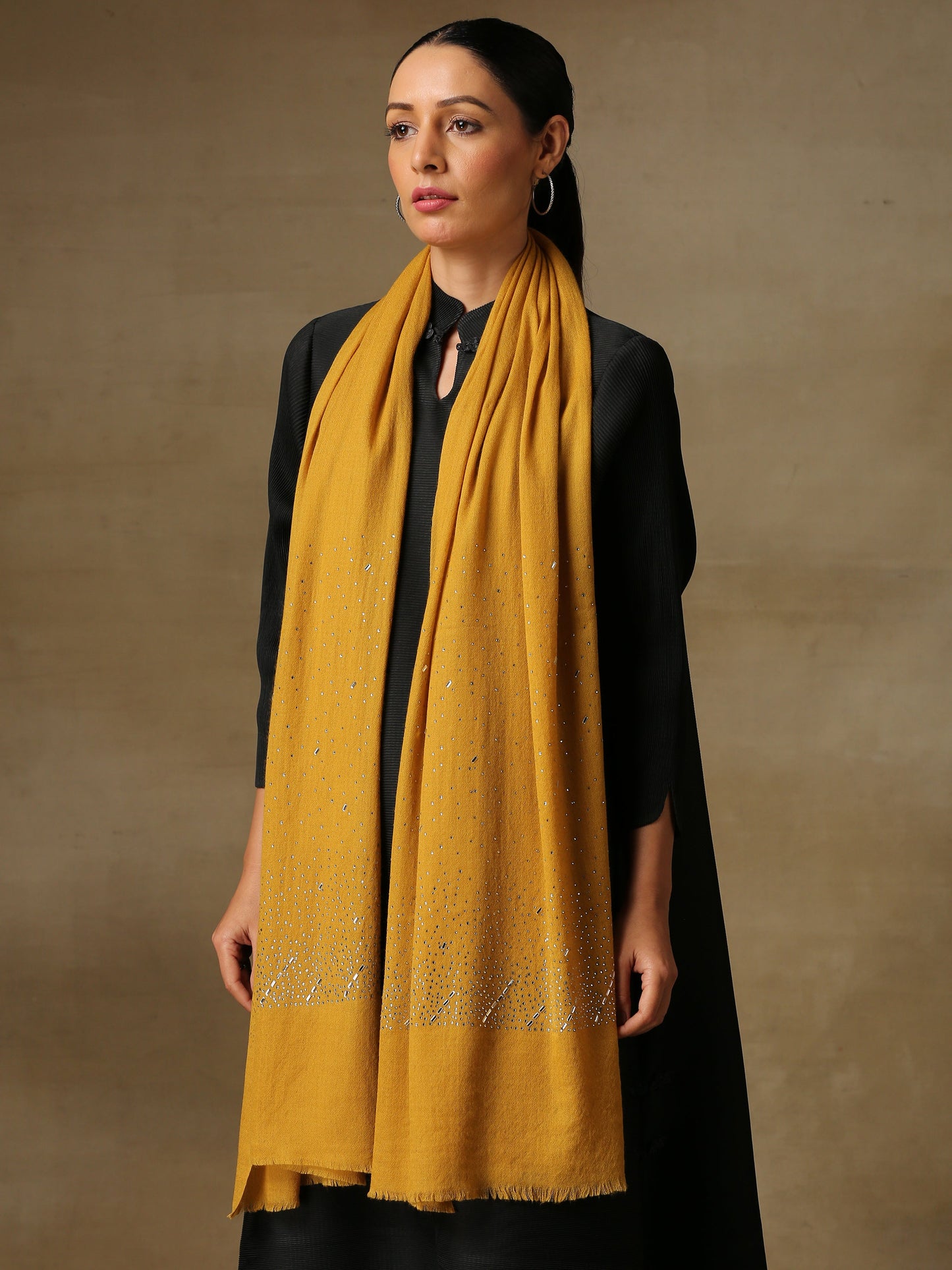 Model is wearing a swarovksi studded Era of Zaywar Palla Stole in the colour mustard. . 