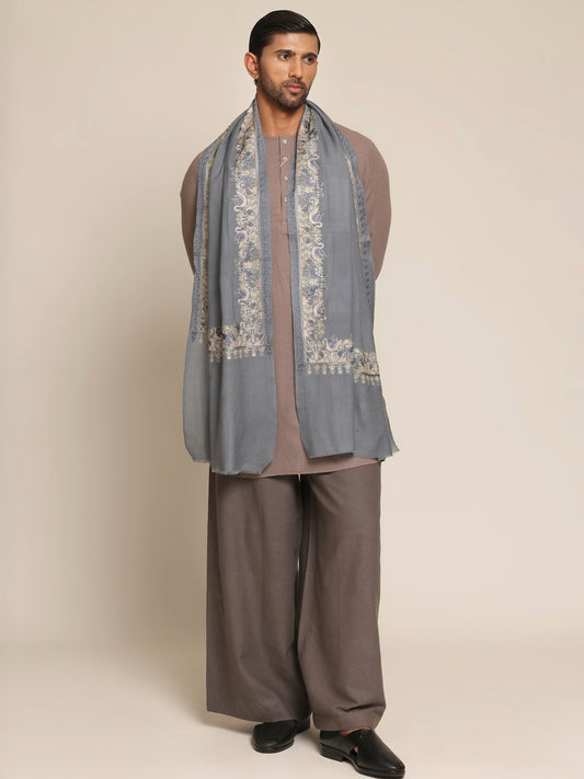 Man wearing a traditional outfit with a baby blue embroidered stole.