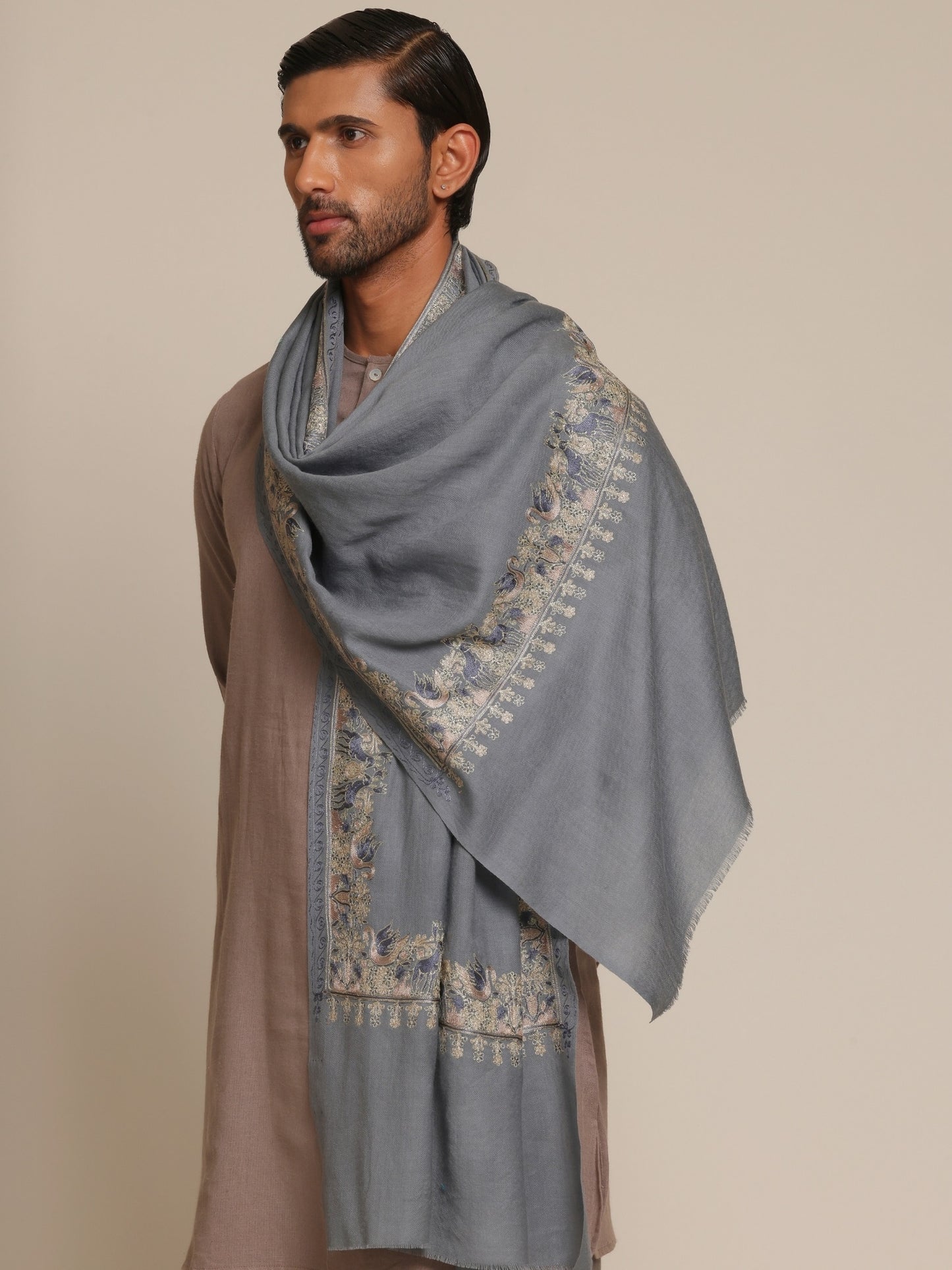 Man wearing a traditional outfit with a baby blue embroidered stole.