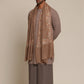 Man wearing a brown traditional outfit with a woolen stole