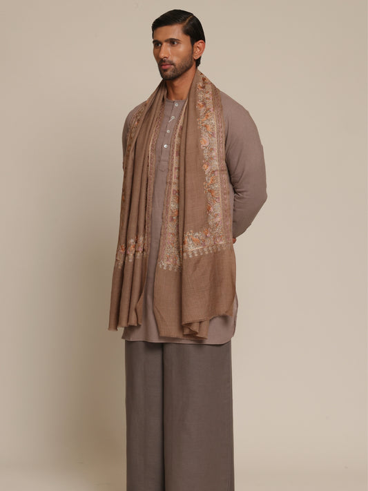 Man wearing a brown traditional outfit with a woolen stole