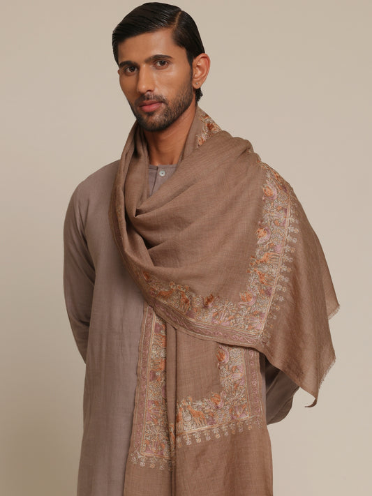 Man wearing a brown traditional outfit with a woolen stole