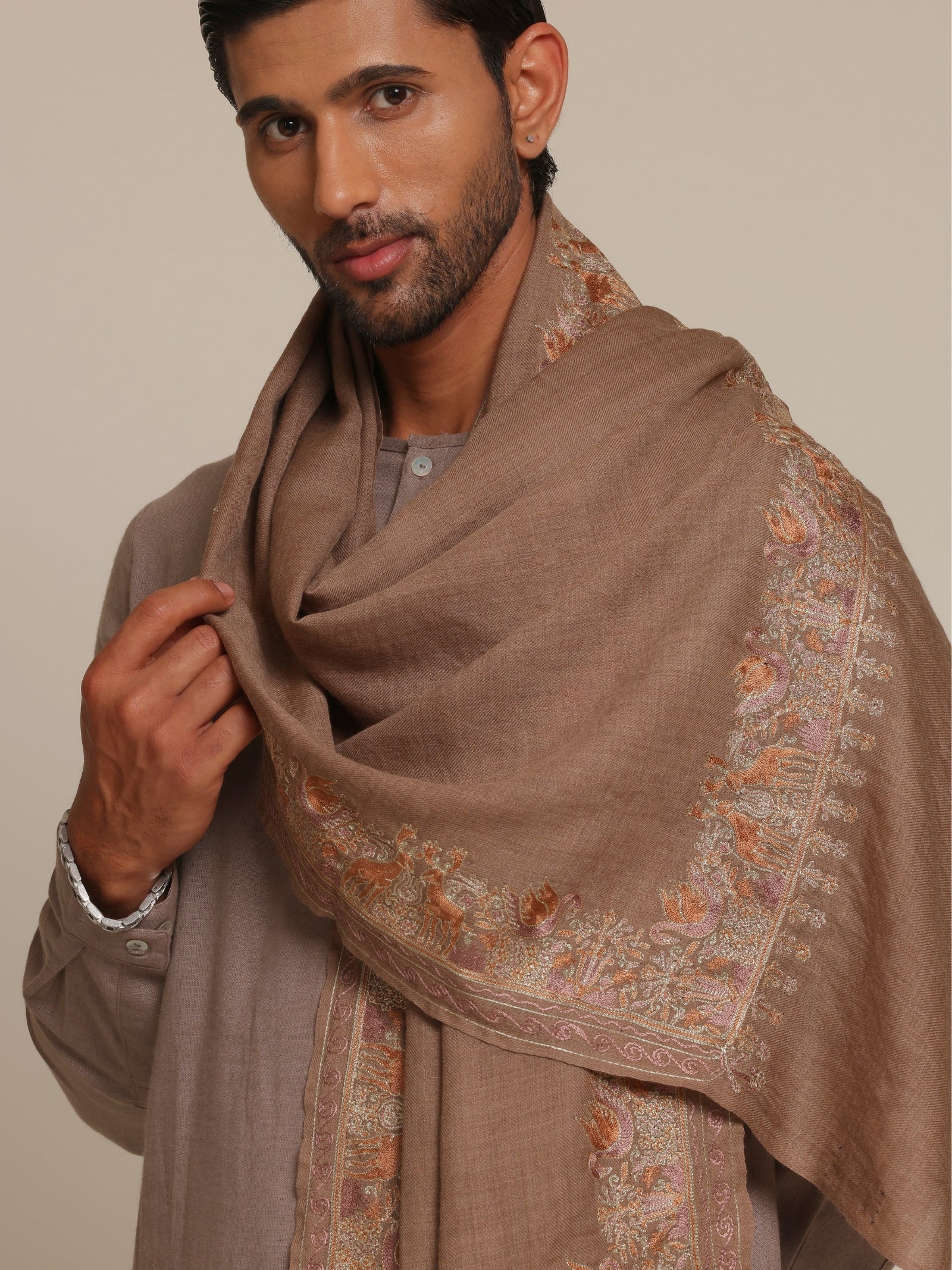 Man wearing a brown traditional outfit with a woolen stole