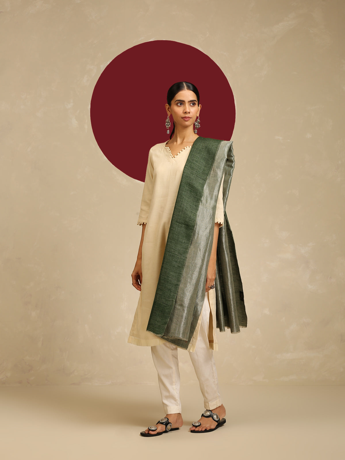 Model is wearing pashmina reversible shawl in green with silver at the back. 
