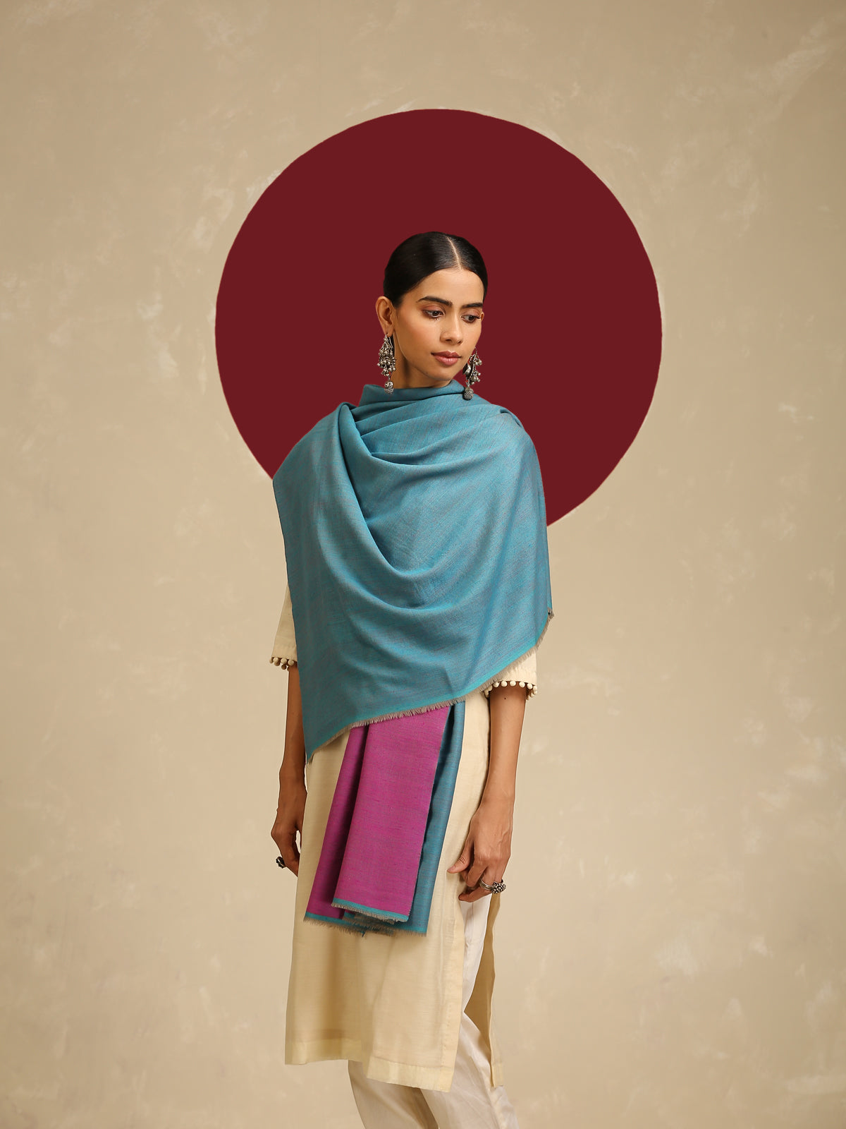 Model is wearing pashmina reversible shawl in pink with blue at the back.