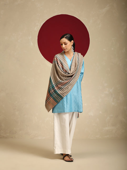 Model is wearing a pashmina check stole in multicoloured hues of orange, blue and green stripes/crosslines on a natural base.