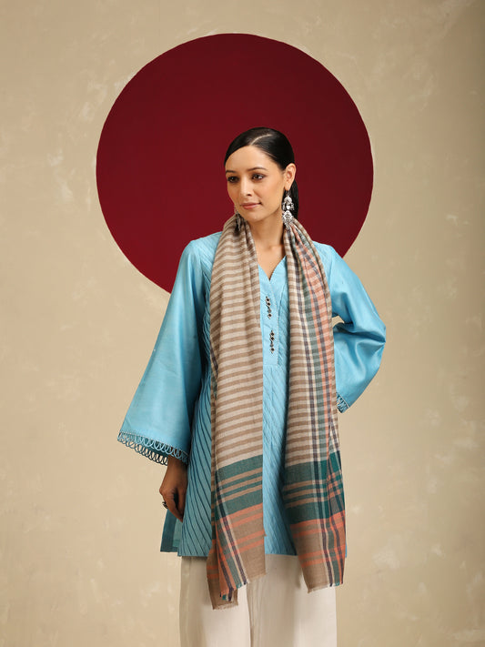 Model is wearing a pashmina check stole in multicoloured hues of orange, blue and green stripes/crosslines on a natural base.