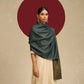 Model is wearing pashmina reversible shawl in olive with blue at the back.