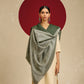 Model is wearing pashmina reversible shawl in green with silver at the back.