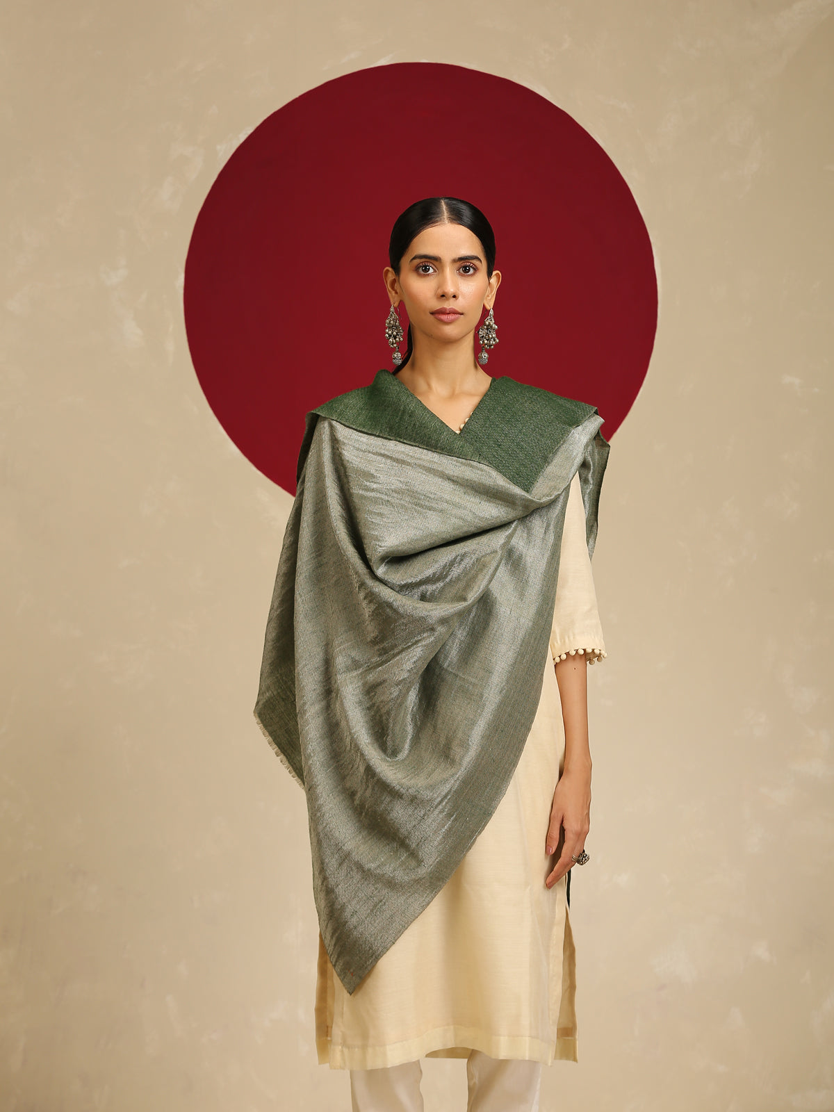 Model is wearing pashmina reversible shawl in green with silver at the back.