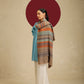 Model is wear a pashmina check stole featuring multi colored stripes on a toosh coloured base.