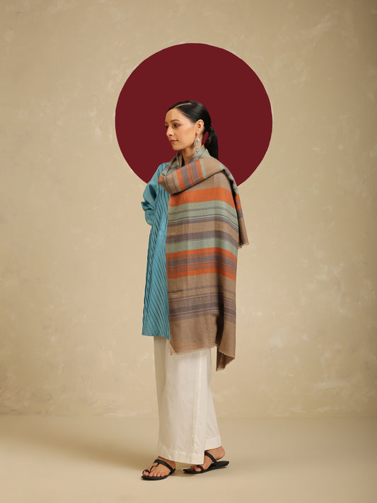 Model is wear a pashmina check stole featuring multi colored stripes on a toosh coloured base.