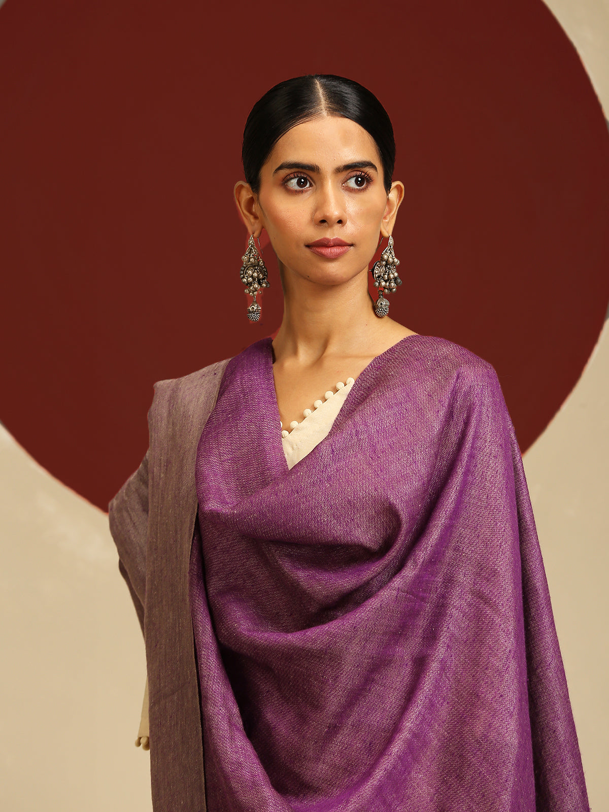 Model is wearing pashmina reversible shawl in purple with silver at the back.