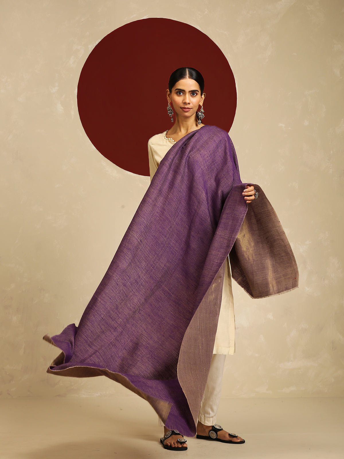 Model is wearing pashmina reversible shawl in purple with gold at the back. 
