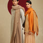 Model is wearing pashmina reversible shawl in orange with gold at the back.