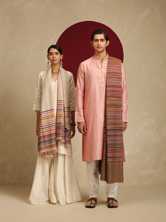 The model on the left is wearing a Pashmina Striped stole from shaza in a multicoloured stripes pattern on a white base. 