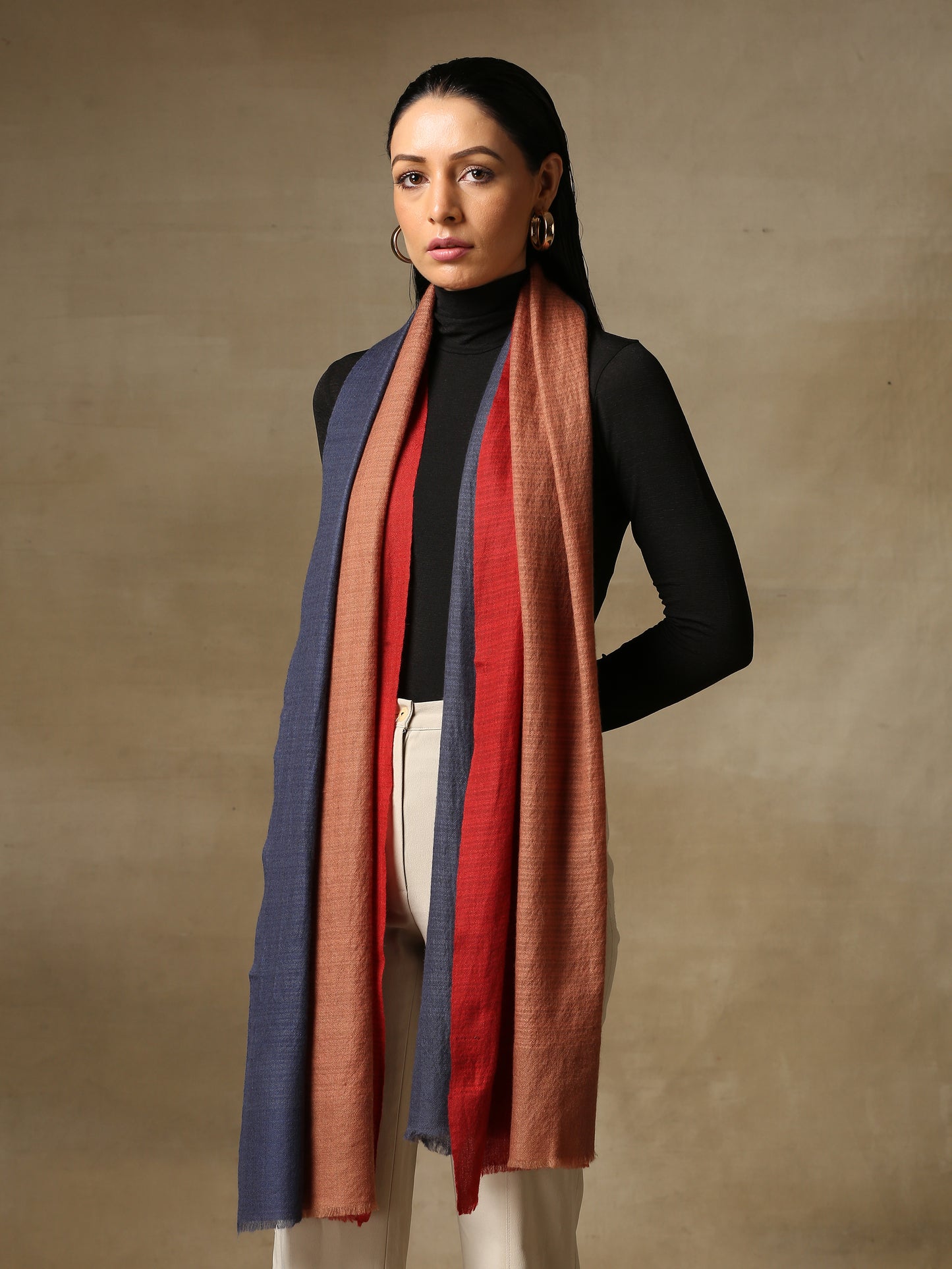 Model is wearing a Pashmina Ombre stole in self weave in the colours crimson orange & blue. 