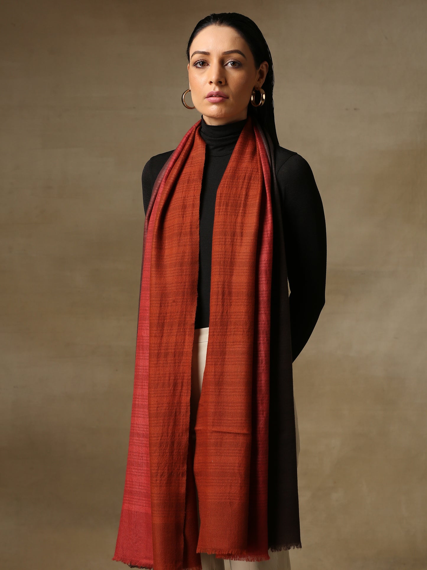 Model is wearing a Pashmina Ombre stole in Self weave in the colours charcoal black and red. 