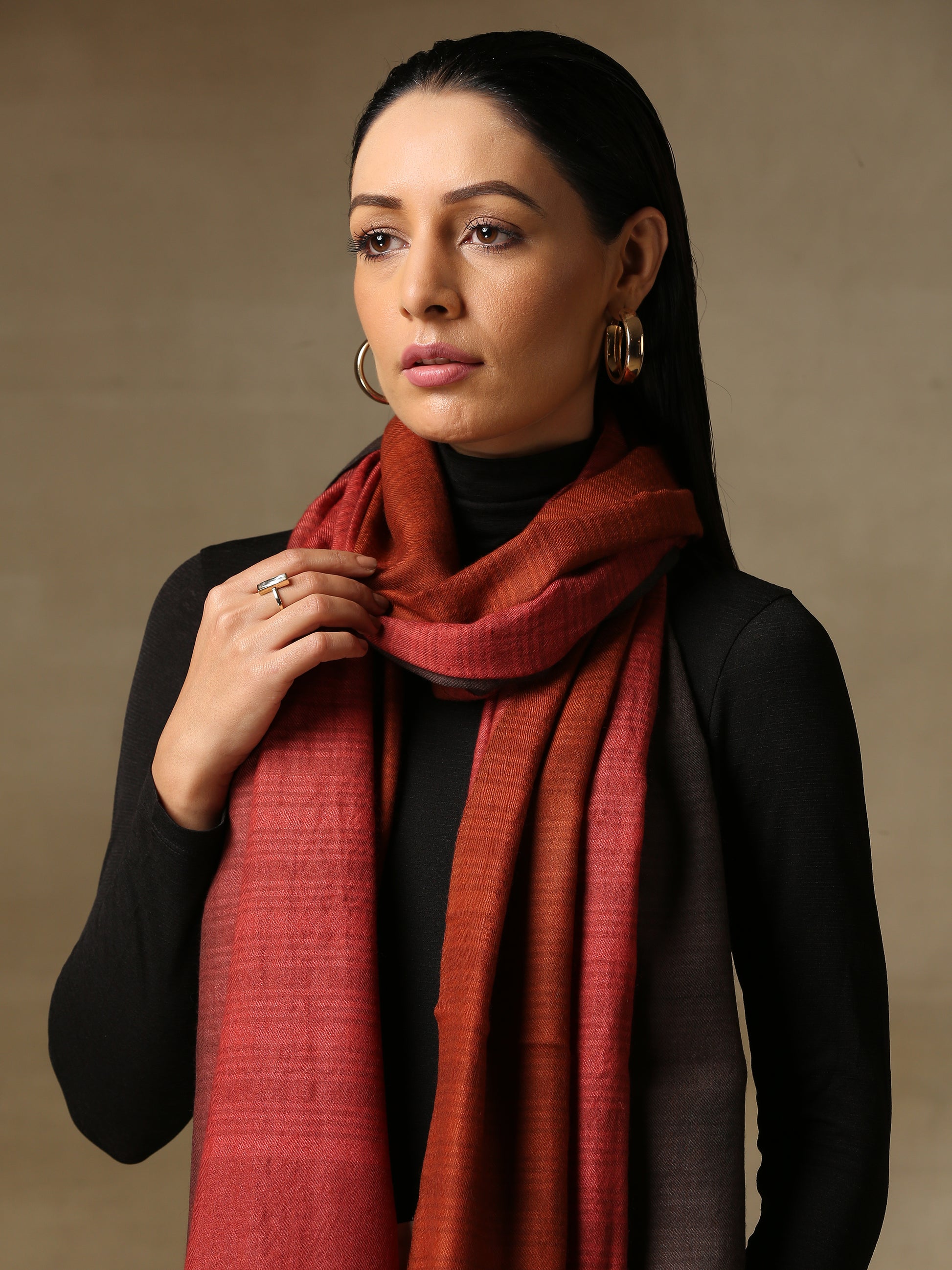 Model is wearing a Pashmina Ombre stole in Self weave in the colours charcoal black and red. 