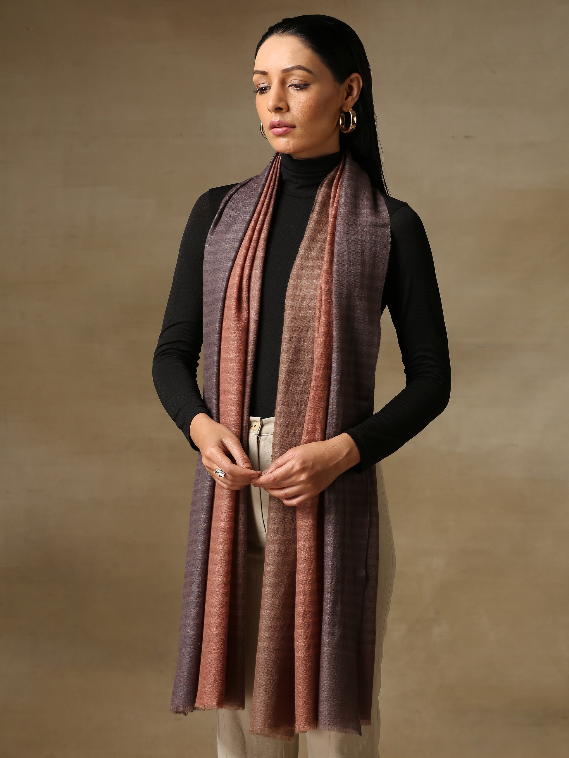 Model is wearing a Pashmina ombre stole in self weave in the colour dusky orange. 