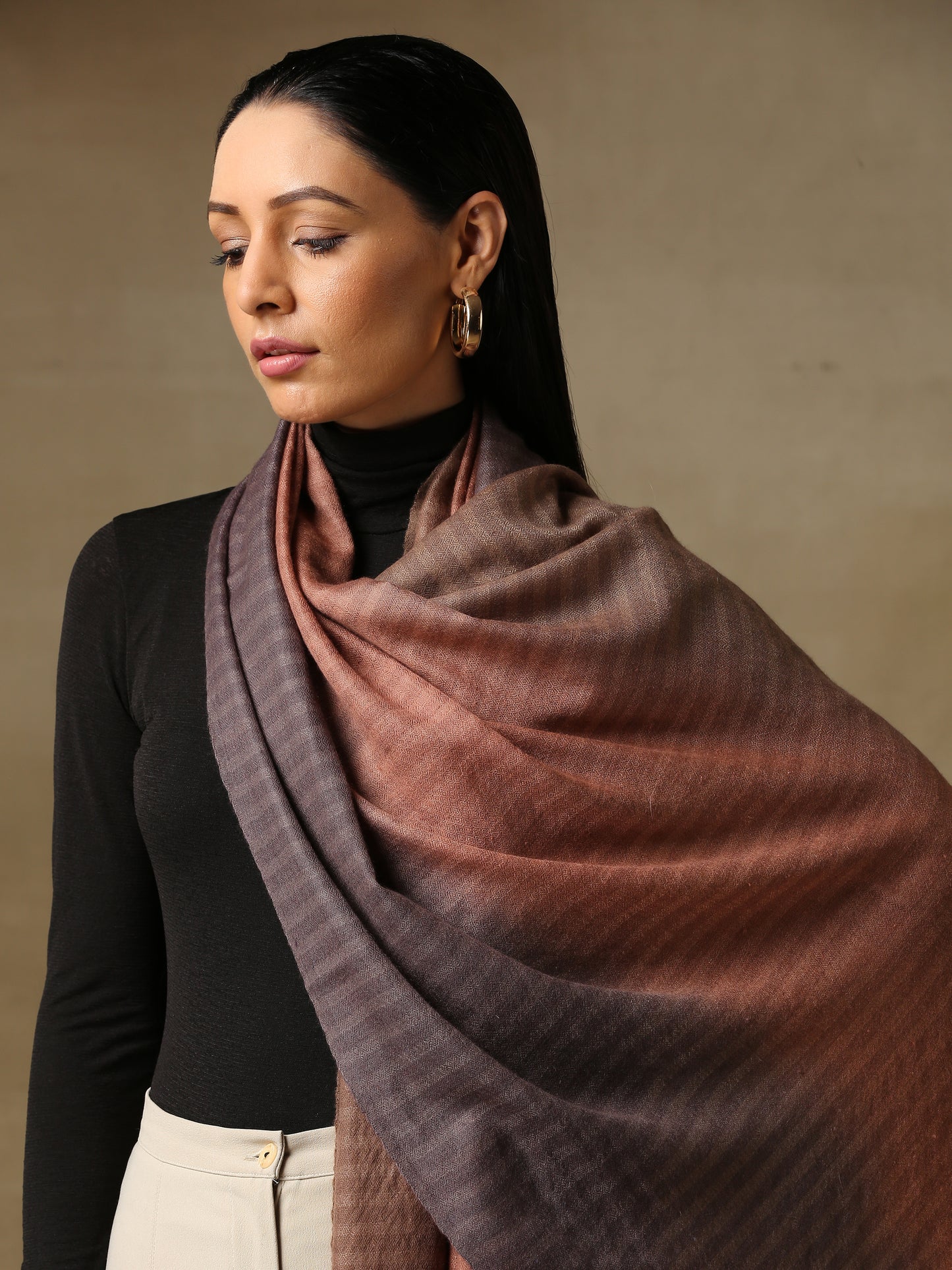 Model is wearing a Pashmina ombre stole in self weave in the colour dusky orange. 