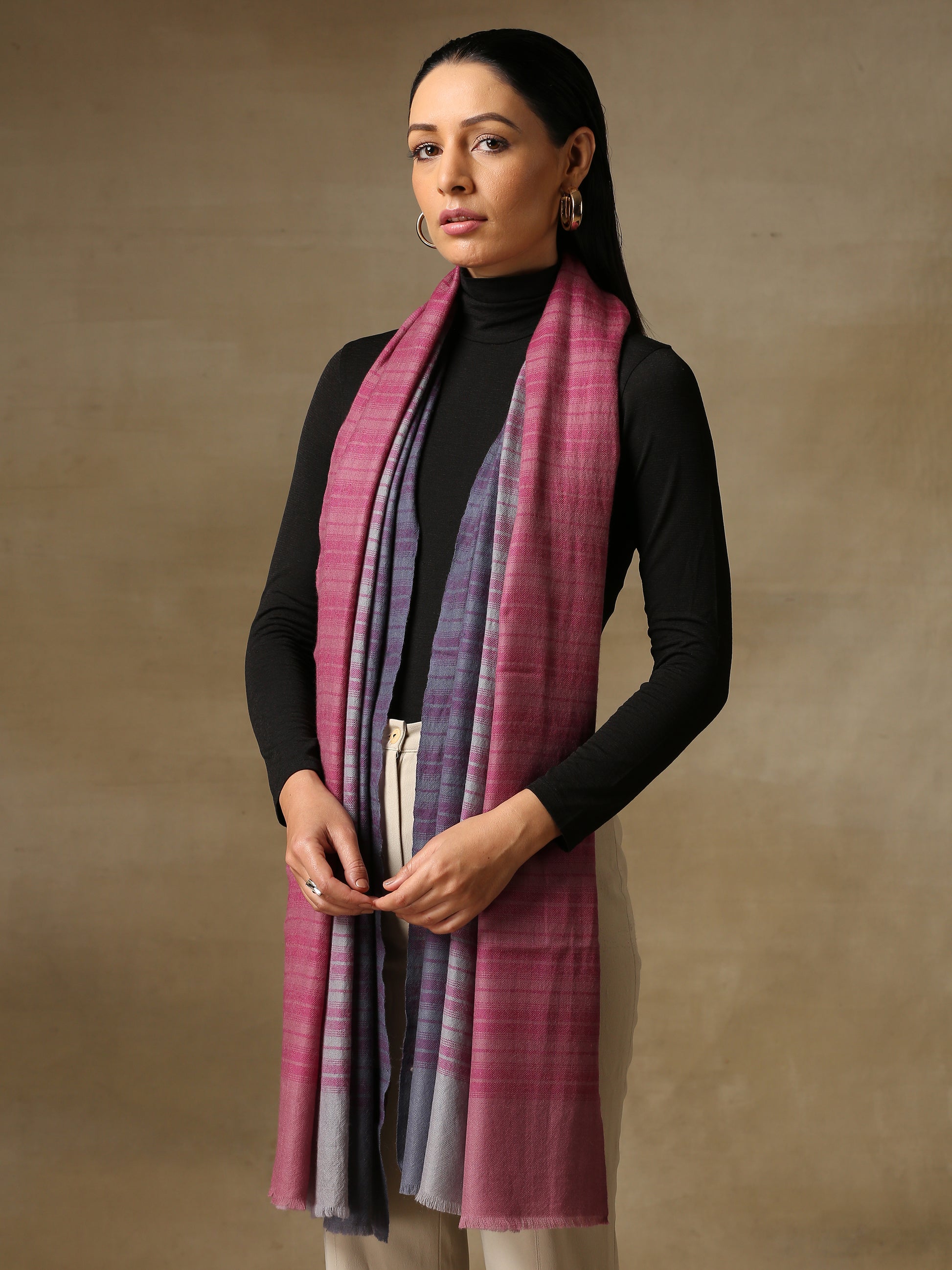 Model is wearing a Pashmina Ombre stole in self weave in the colours gray, pink & purple. 