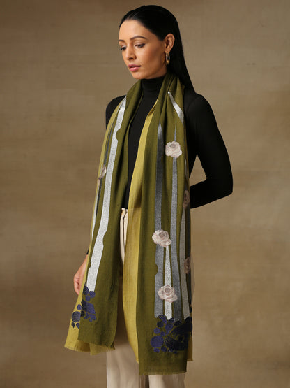 Model is wearing a cashmere machine embroidery stole from Shaza, featuring threadwork floral motifs, in the colour olive.