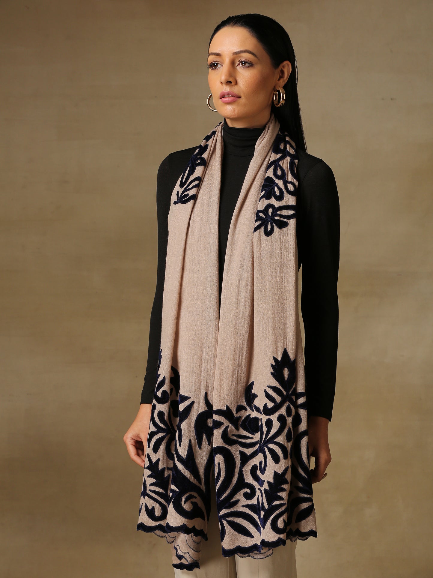 Model is wearing a Velvet Affair stole from Shaza featuring dark blue velvet applique on a light toosh coloured cashmere stole. 