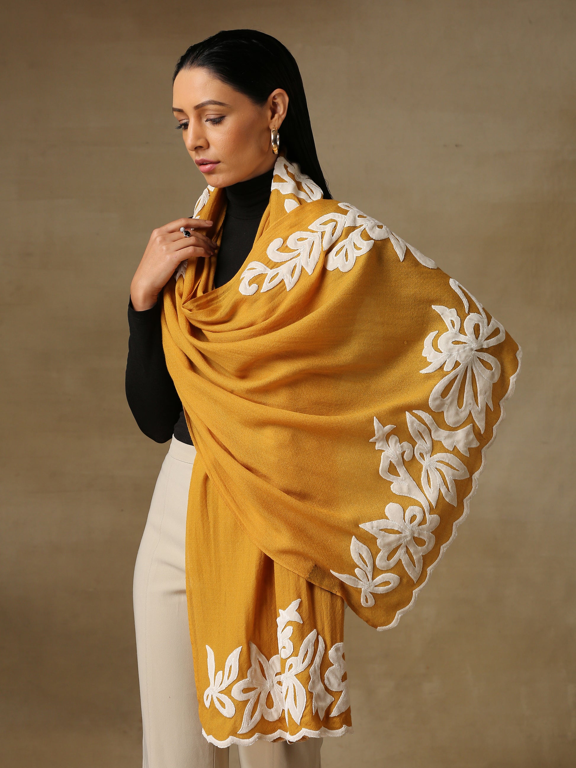 Model is wearing a Velvet Affair stole from Shaza featuring white velvet applique on a mustard coloured cashmere stole.