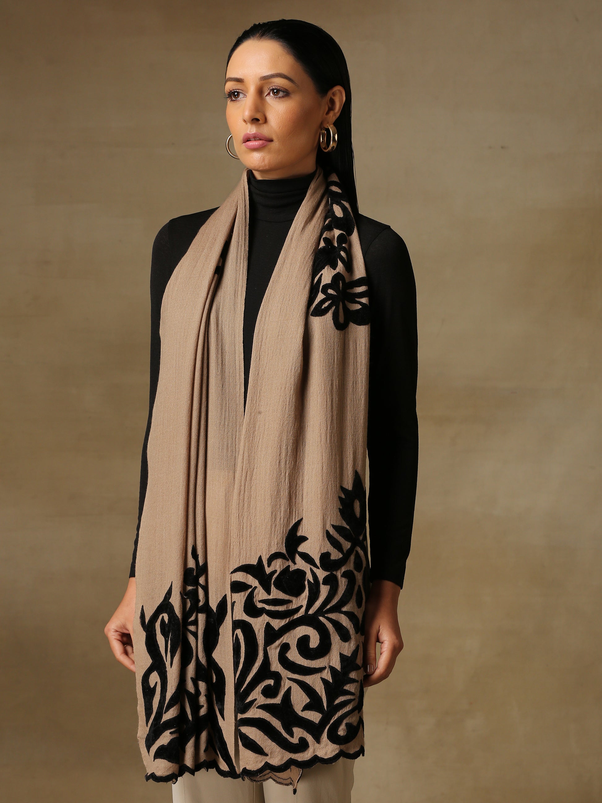 Model is wearing a Velvet Affair stole from Shaza featuring black velvet applique on a toosh coloured cashmere stole. 