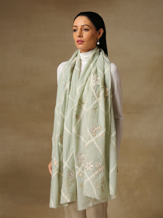 Model is wearing the Daisy pashmina stole in mint green from Shaza, featuring threadwork of interwoven lines and applique of daisy figures on handloomed pashmina. 