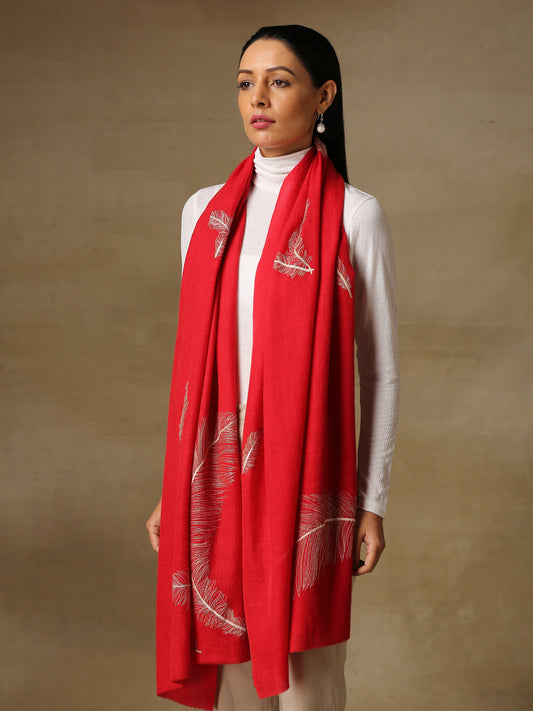 Model is wearing the Feather pashmina stole in the color red, featuring feather shapes hand embroidered using threadwork and zari. 