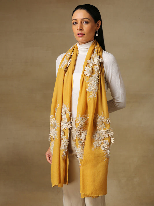 Model is wearing an Elements of Spring pashmina tole by Shaza, featuring applique or chantilly, decorated with delicate threadwork and pearl embroidery on a mustard colour pashmina stole.