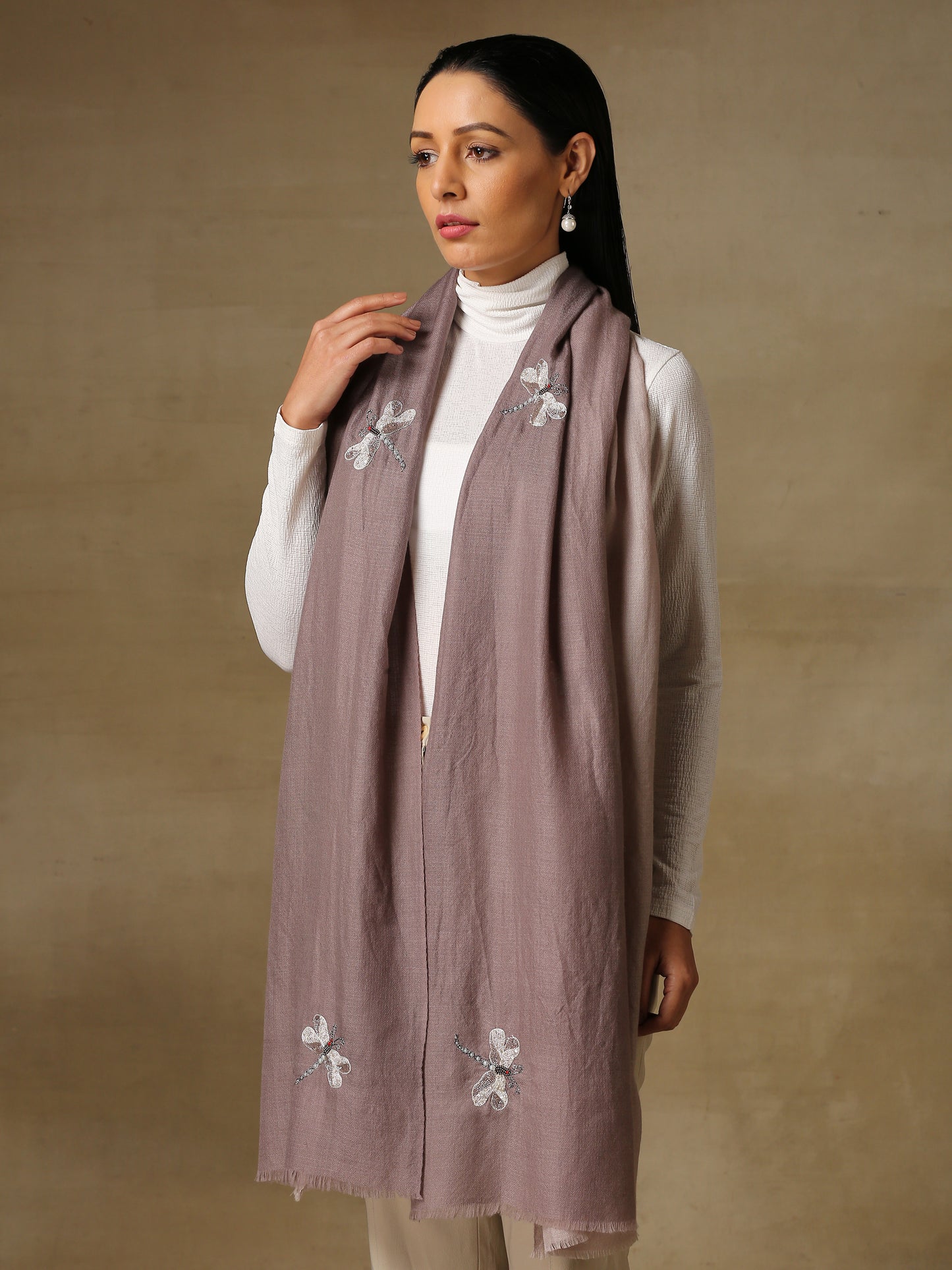 Model is wearing Dragonfly pashmina stole from shaza in the colour fog gray ombre, featuring dragonfly shapes hand embroidered using threadwork, cutdana, shellwork and pearls.