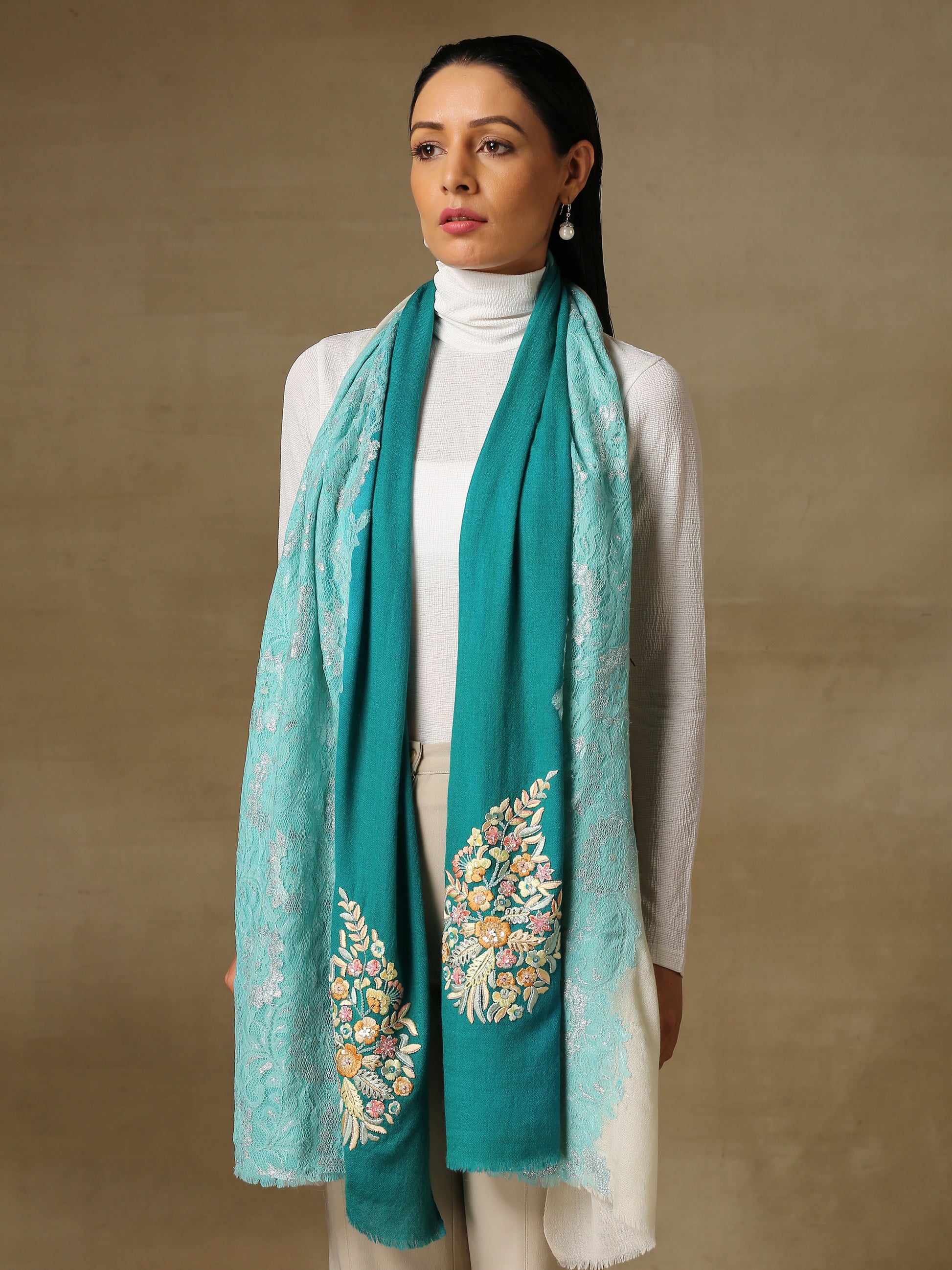 Model is wearing Enchanted pashmina stole from shaza in the colour coral reefs featuring a hand painted ombre in blue and white colours and delicate threadwork embroidery consisting of pearls, shellwork and cutdana.  