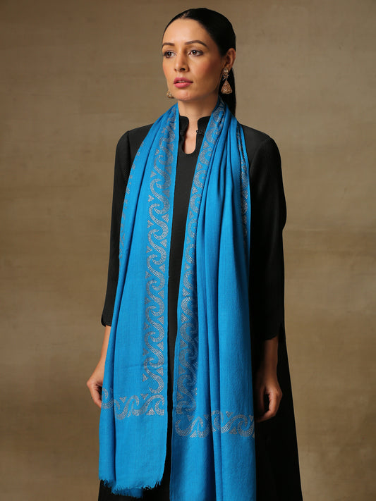 Model is wearing a firozi blue stole from the Era of Zaywar Border Swarovski Stole collection, hand embellished with fine silver swarovski in a waves design