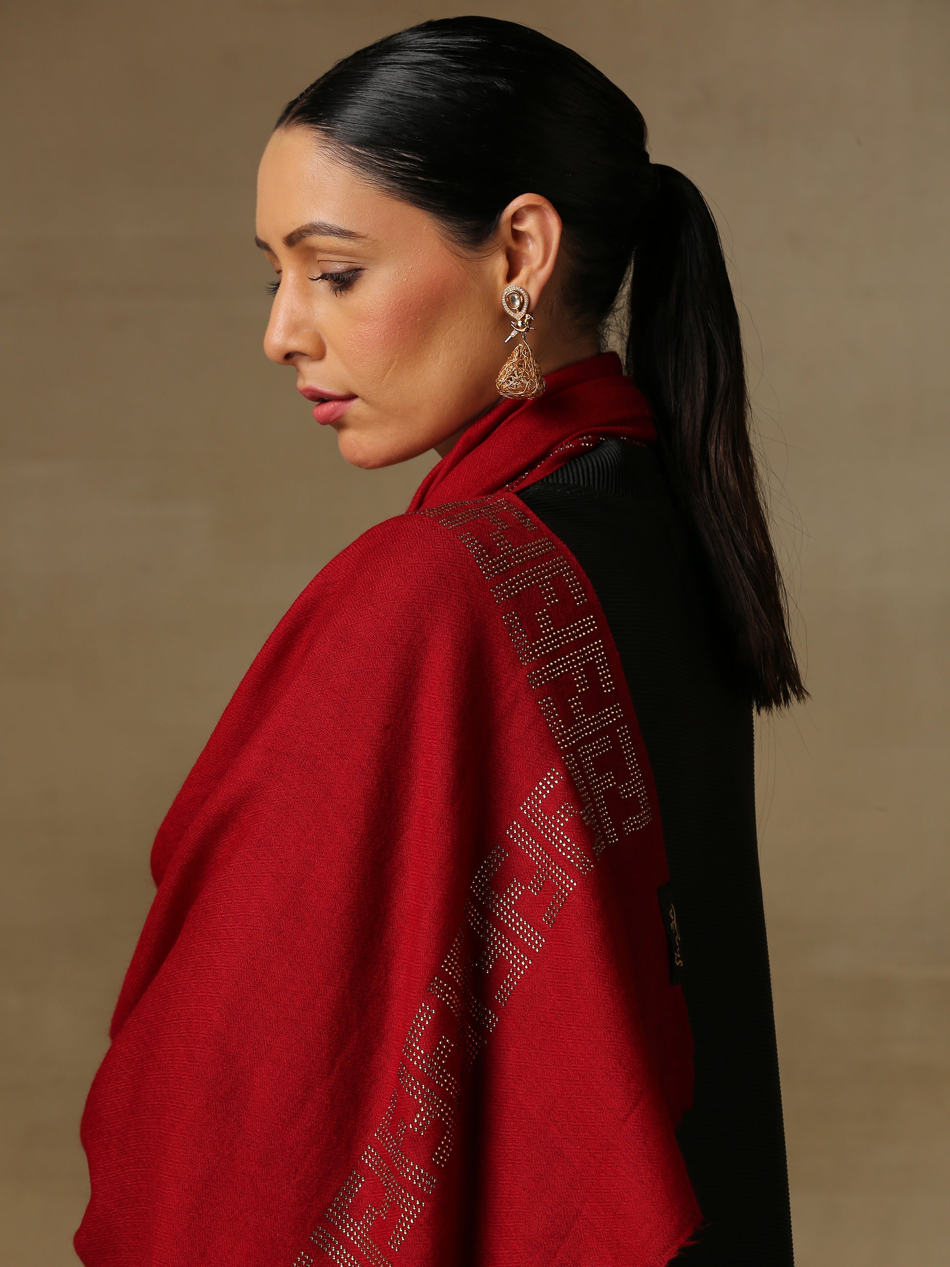 Model is wering a maroon coloured stole from the Era of Zaywar Border Swarovski Stole collection, hand embellished with gold swarovski in an abstract design.