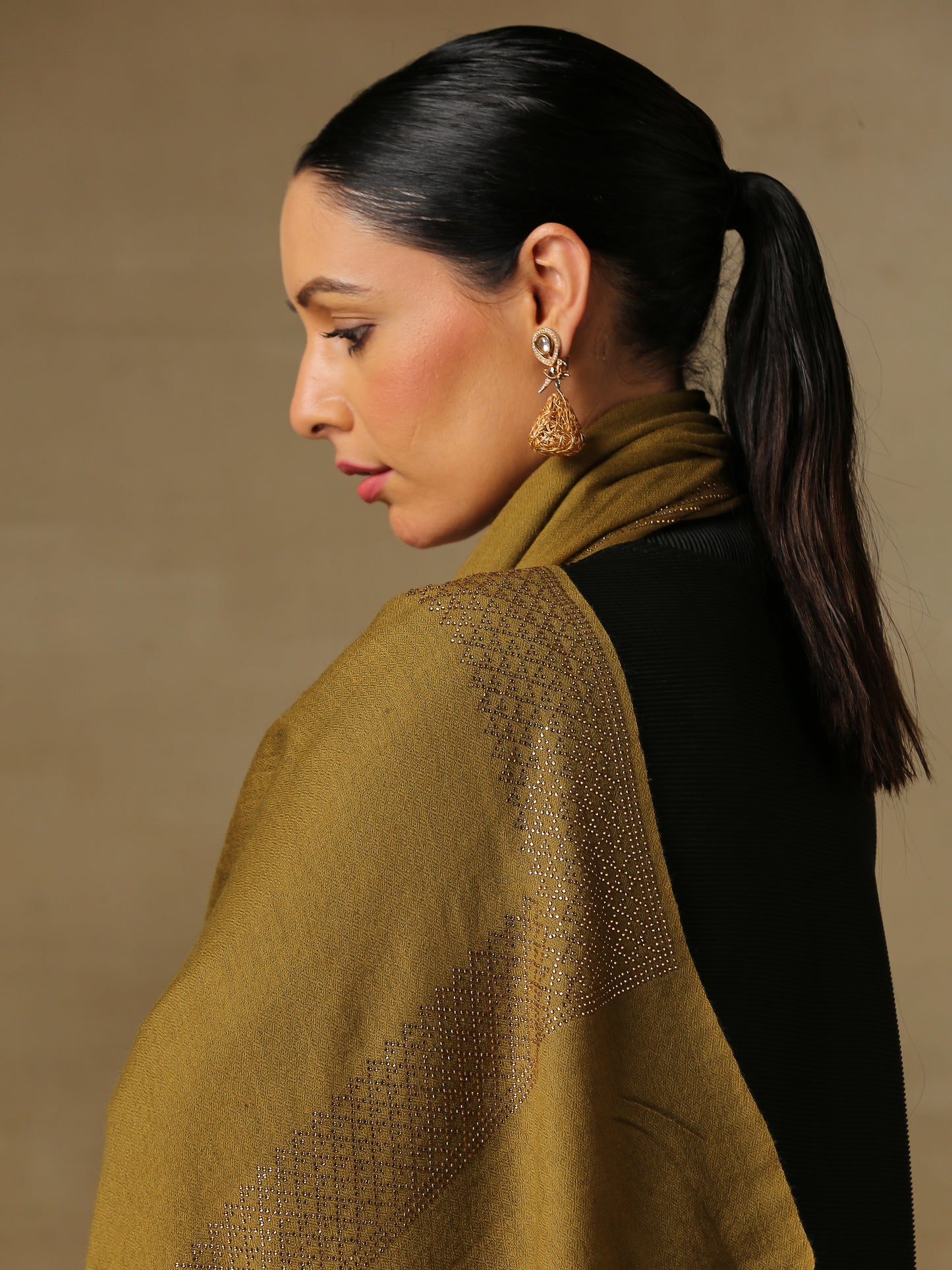Model is wearing a henna coloured stole from the Era of Zaywar Border Swarovski Stole collection, hand embellished with gold swarovski in a cubes design. 