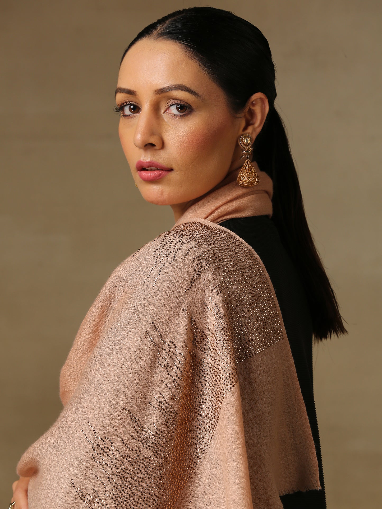 The model is wearing a blush coloured stole from the Era of Zaywar Border Swarovski Stole collection, hand embellished with fine gold swarovski in a flames of fire design. 
