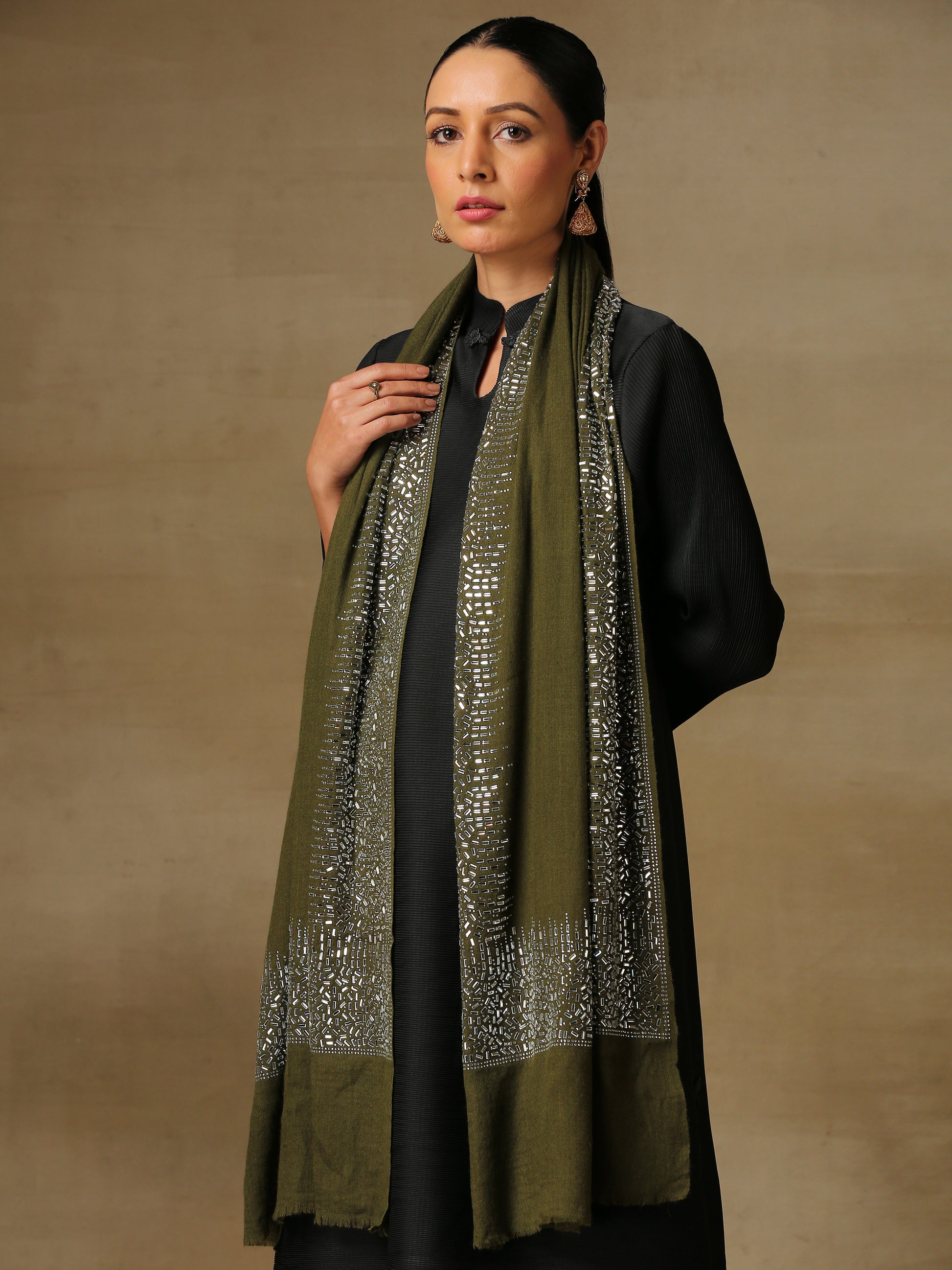 Model is wearing an olive coloured, swarovski studded stole from the Era of Zaywar Magnificent collection, with lavish hand embellished swarovski crystals all along the border. 